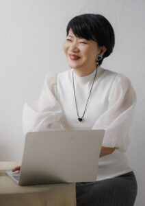 ノートパソコンを前に、優しい笑顔でカウンセリングをしている代表カウンセラーの様子。